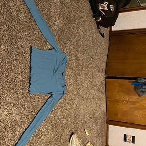 Cropped shirt, v neck, teal color with ruffles on the end of the sleeve